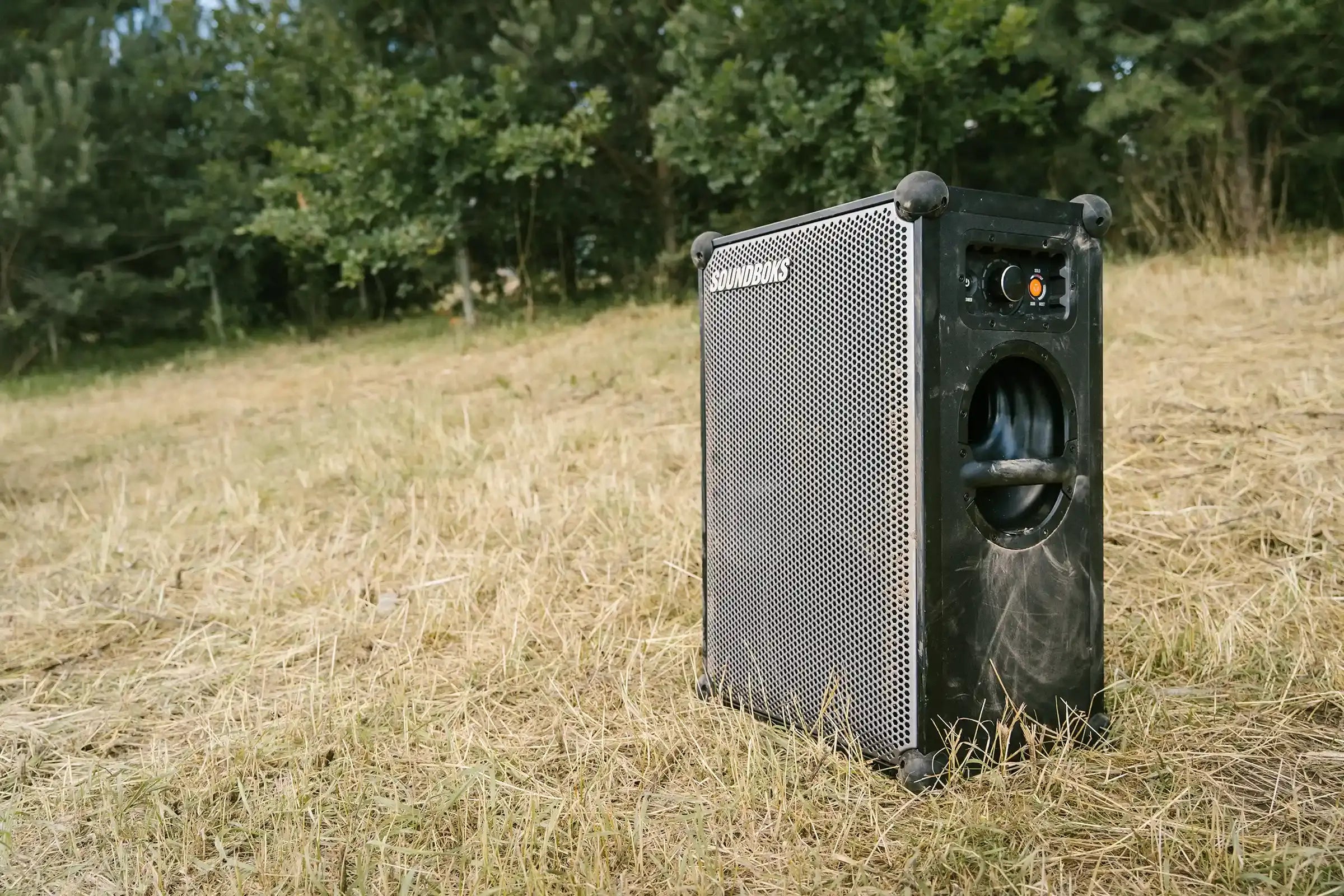 A dirty Soundboks 4 standing on grass