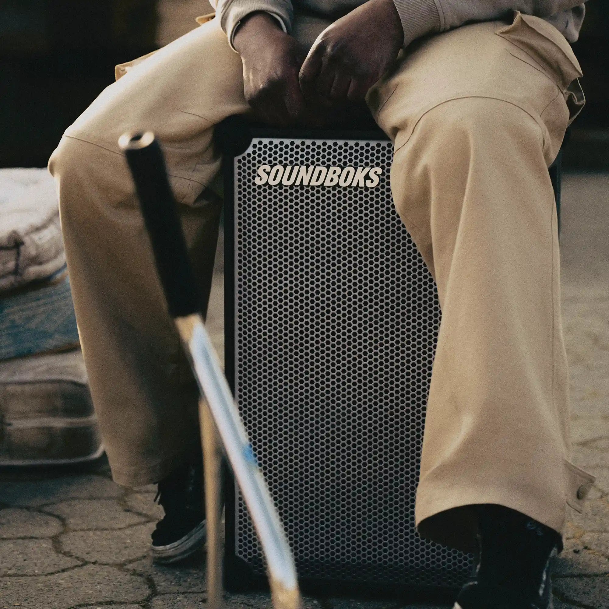 Person sitting on Metallic grey Soundboks 4.